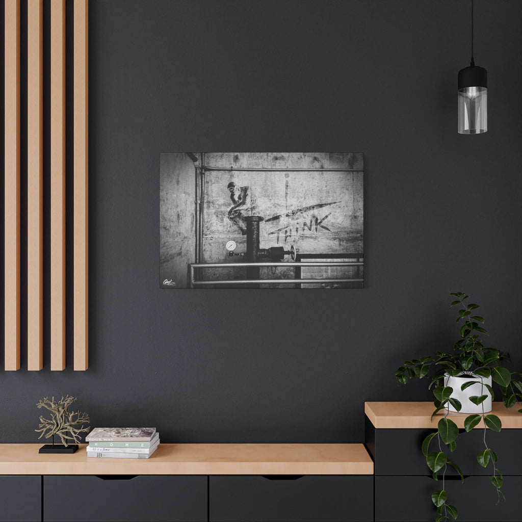 I Overthink canvas on a charcoal wall by wood slats, gritty parking-garage wall with a stenciled THINK