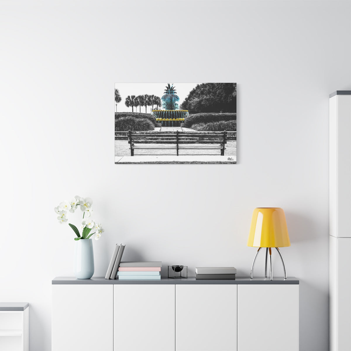 The Pineapple of Peace medium canvas above a white sideboard and yellow lamp, pineapple fountain behind a park bench