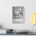 Heartbreak small canvas beside a yellow desk lamp, broad black charcoal-style strokes over a pale textured ground
