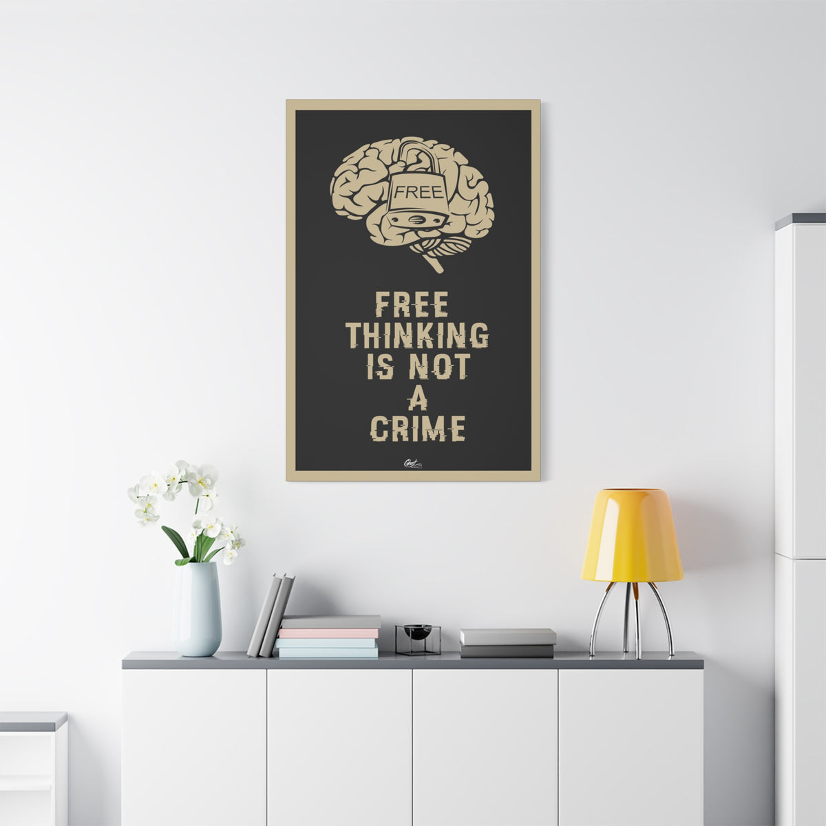 Free Thinking Is Not a Crime medium canvas above a white sideboard and yellow lamp, padlocked brain in beige on charcoal