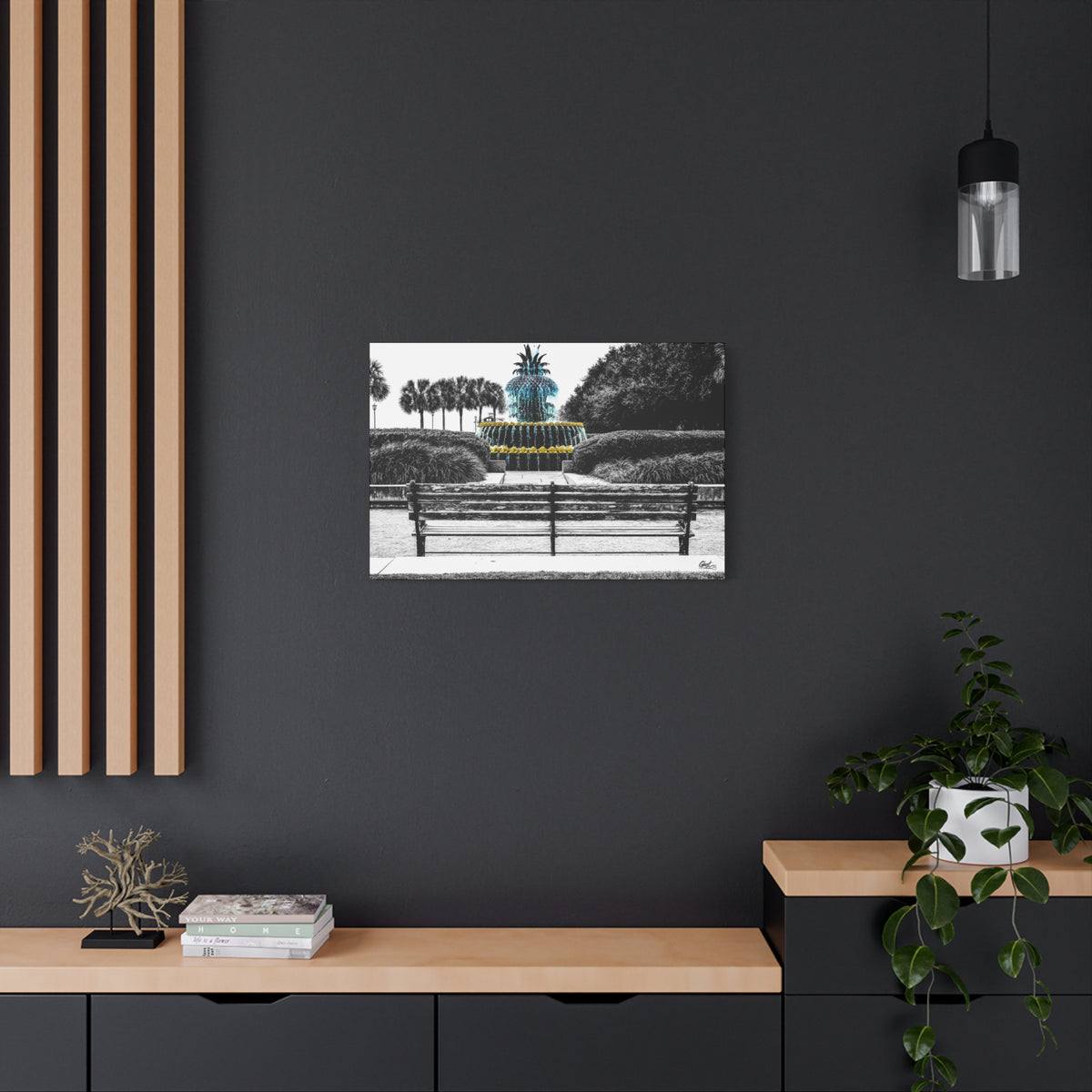 The Pineapple of Peace medium canvas on a charcoal wall over an oak shelf, pineapple fountain behind a park bench