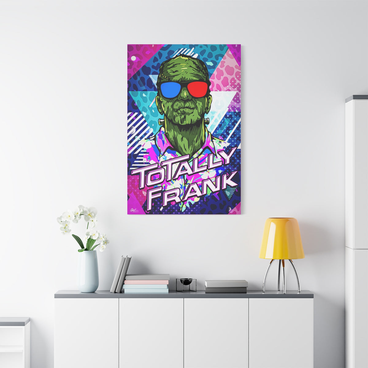 Monster Vibes medium canvas above a white sideboard and yellow lamp, neon pop-art monster with bold block lettering