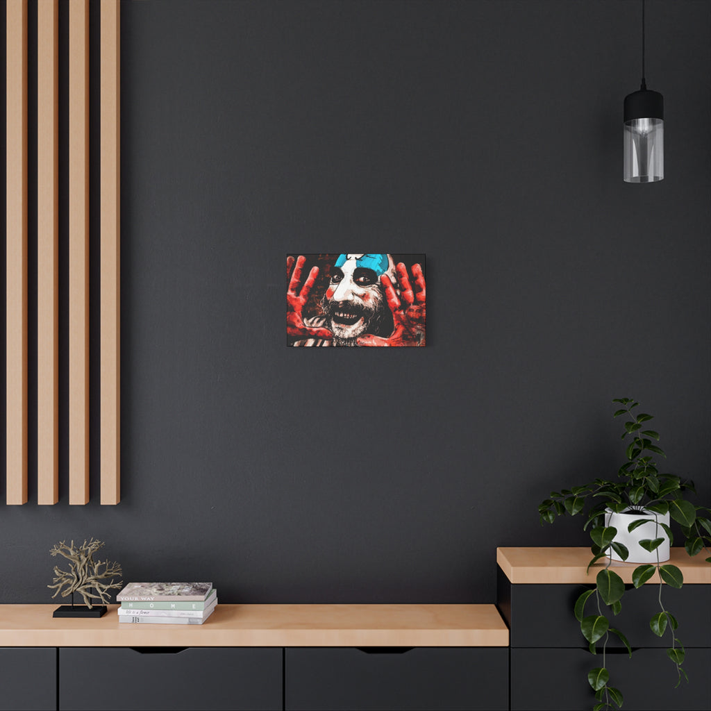 Don't Turn Your Back canvas on a charcoal wall by wood slats, grinning clown with blue-and-white face paint and red hands