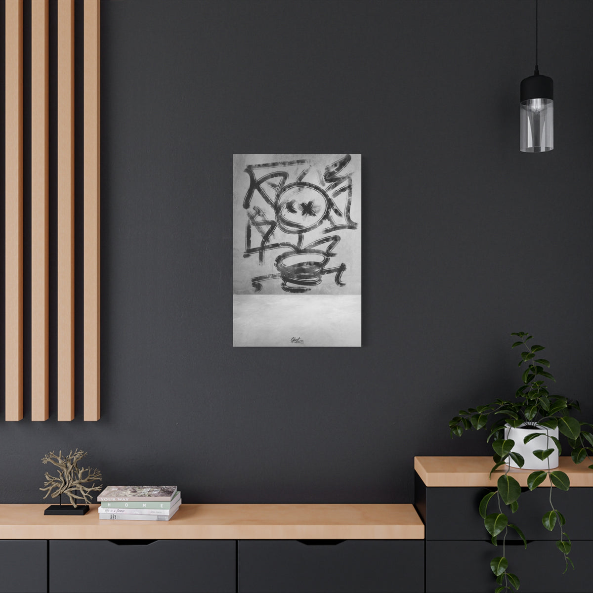 Going Crazy canvas on a charcoal wall over an oak shelf, loose black marks circling a central form above a small cup shape