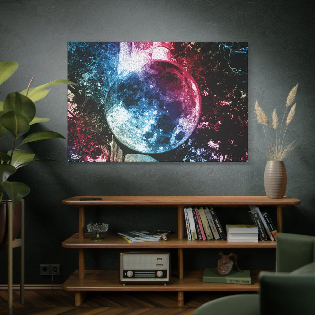 Universe in a Mirror canvas on a green-gray wall over bookshelves, glowing mirrored orb floating in a dreamy pink-blue sky