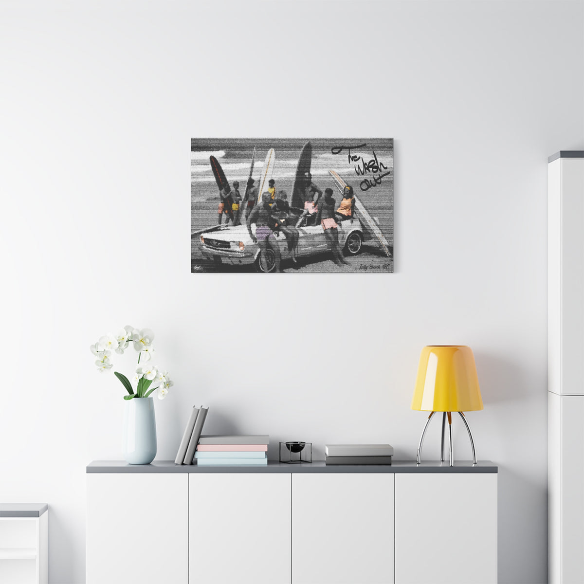 The Wash Out canvas above a white sideboard and yellow lamp, grainy beach-day photo with a surfboard-loaded convertible