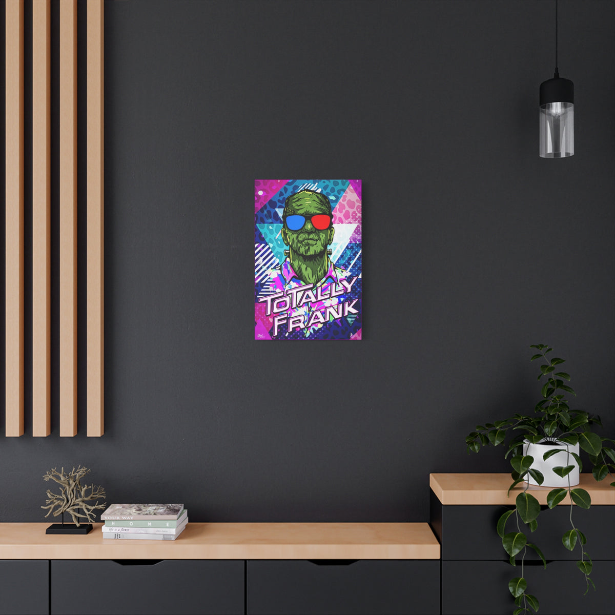 Monster Vibes small canvas on a charcoal wall by wood slats, neon pop-art monster with bold block lettering