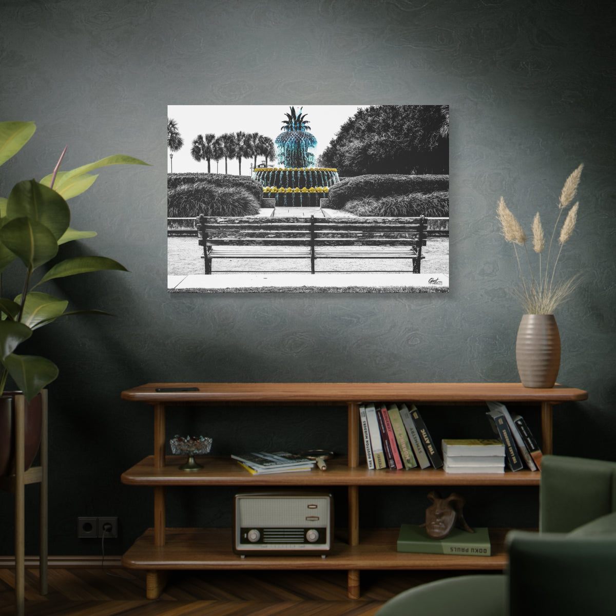 The Pineapple of Peace large canvas on a green-gray wall over bookshelves, pineapple fountain behind a park bench