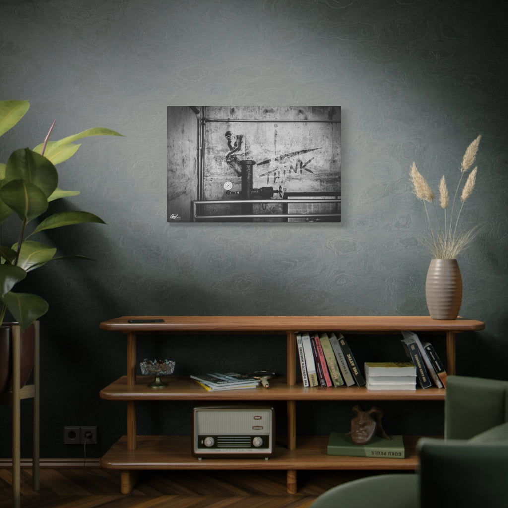 I Overthink large canvas above a wooden bookshelf, stenciled THINK with pipes and gauges on concrete, black and white