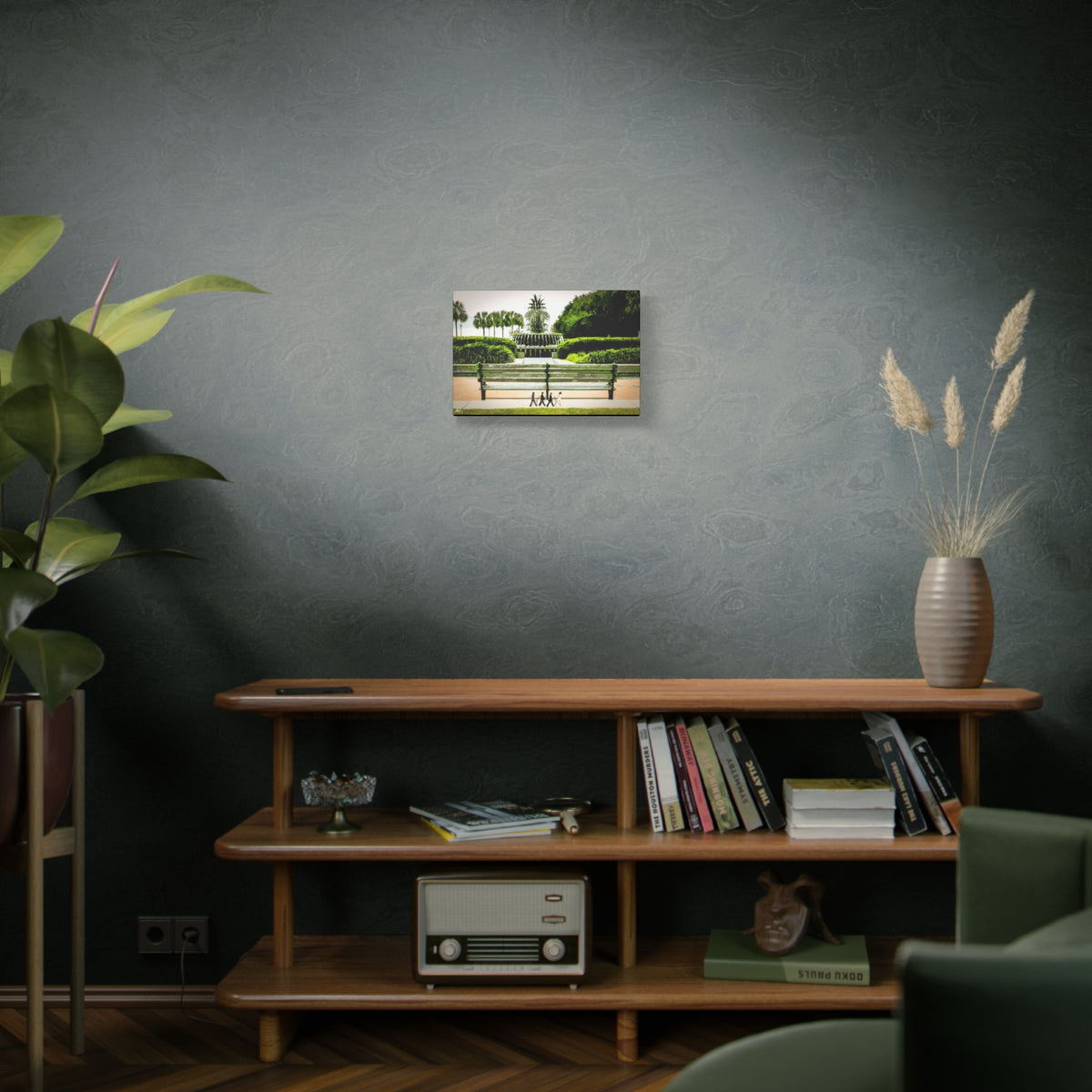 Pineapple Crossing small canvas above a wooden bookshelf, Pineapple Fountain with palmettos, hedges and four walkers