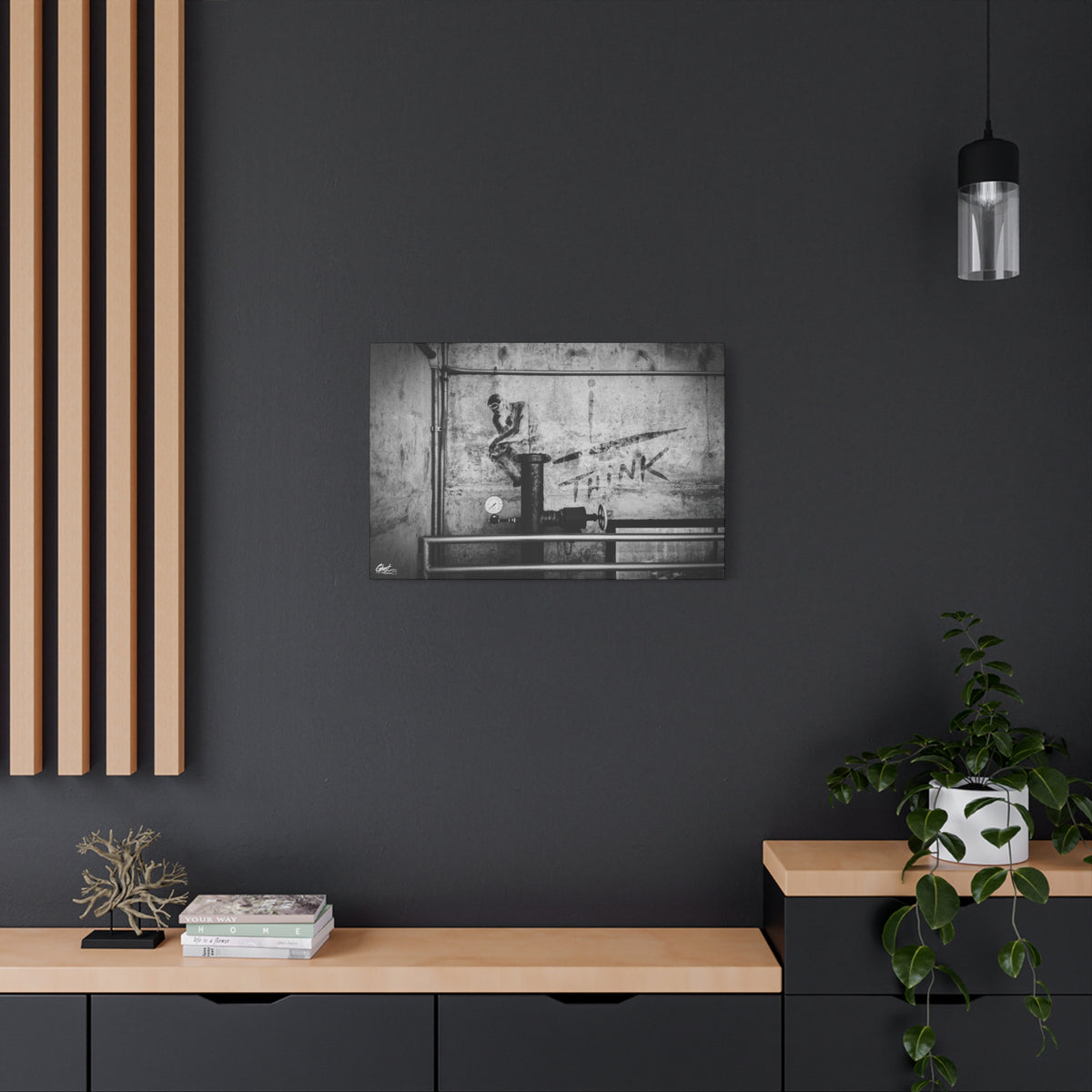 I Overthink canvas on a charcoal wall over an oak shelf, stenciled THINK with pipes and gauges on concrete, black and white