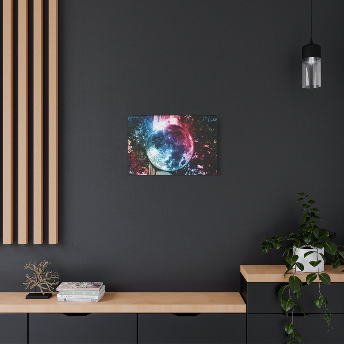 Universe in a Mirror canvas on a charcoal wall over an oak shelf, glowing mirrored orb floating in a dreamy pink-blue sky