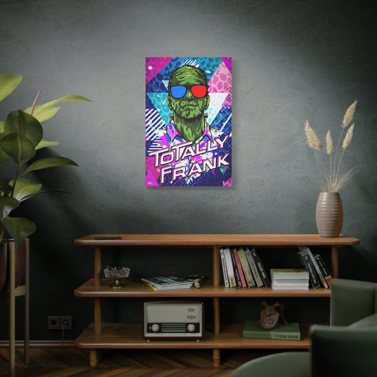 Monster Vibes canvas on a green-gray wall over bookshelves, green monster in red-and-blue 3D glasses and a tropical shirt