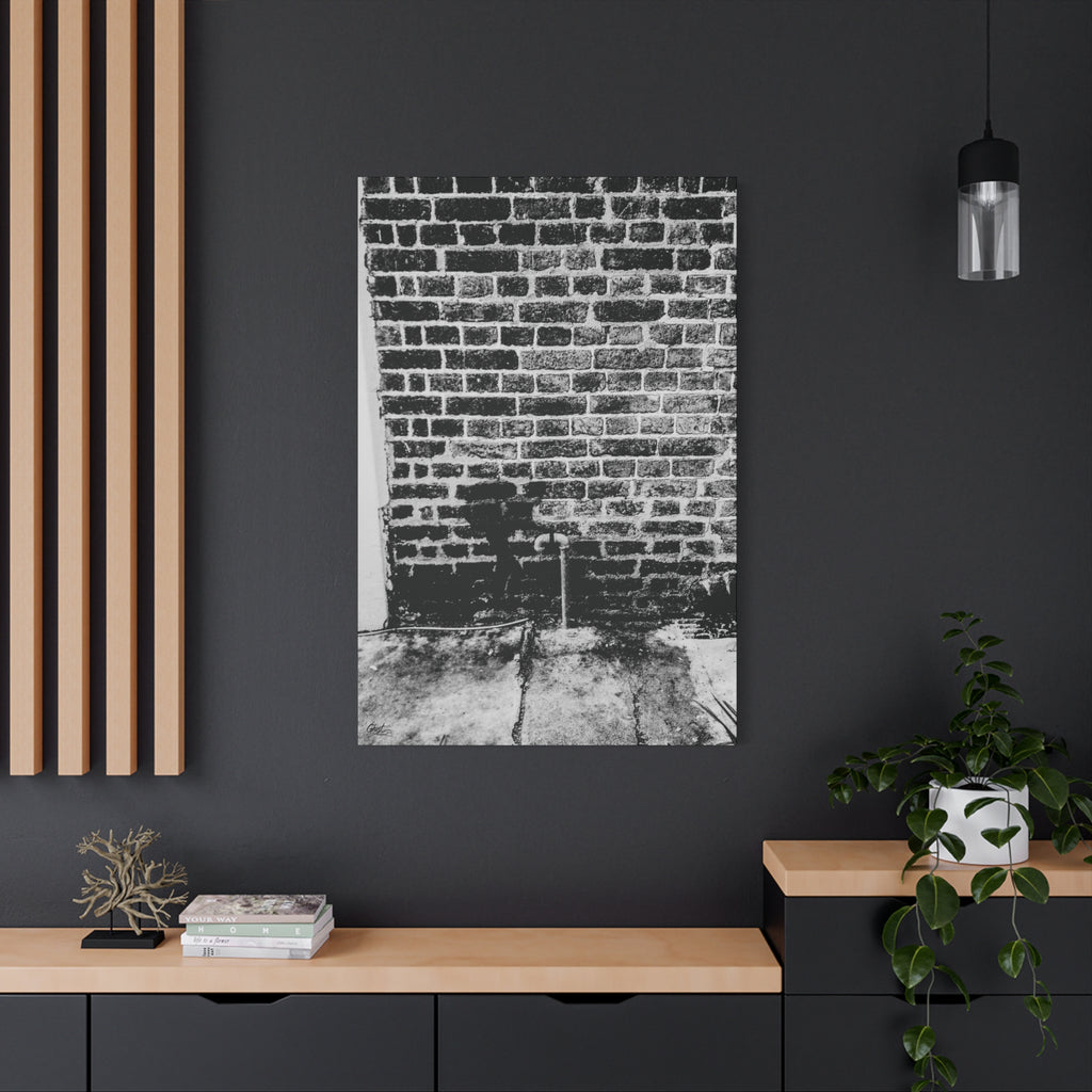 A Little Hiking in Charleston canvas on a charcoal wall by wood slats, high-contrast brick wall with a tiny stencil hiker