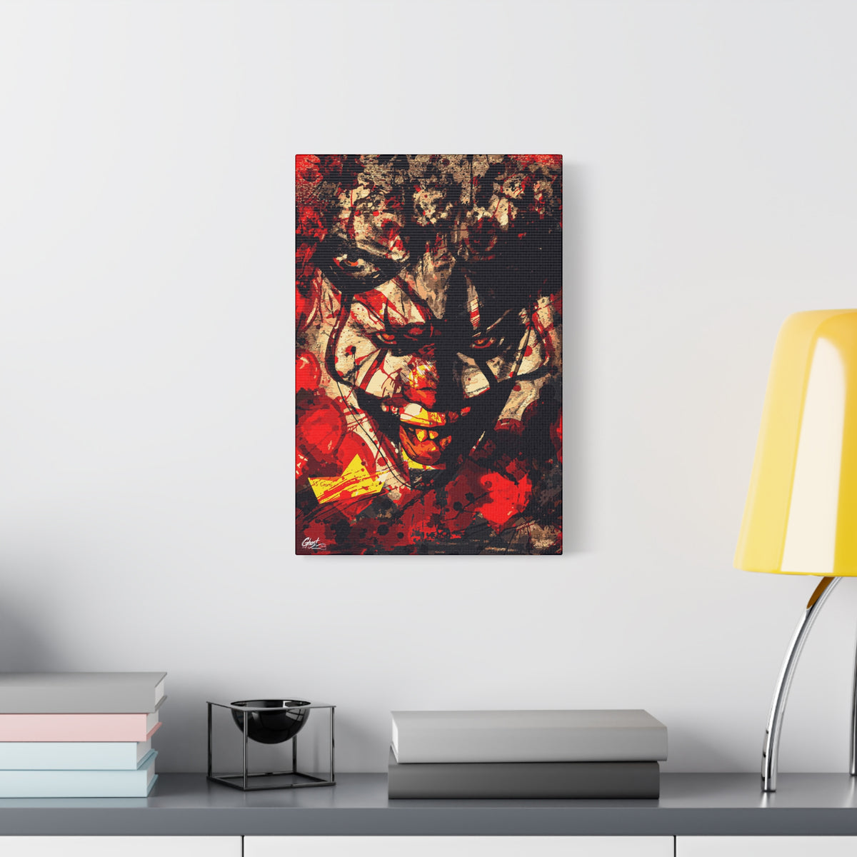 Down in a Drain medium canvas beside a yellow desk lamp, leering clown face in distressed red, black and cream