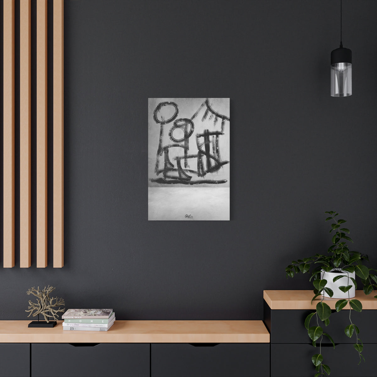 The Question medium canvas on a charcoal wall over an oak shelf, hand-brushed black arcs reading as figures and a horizon