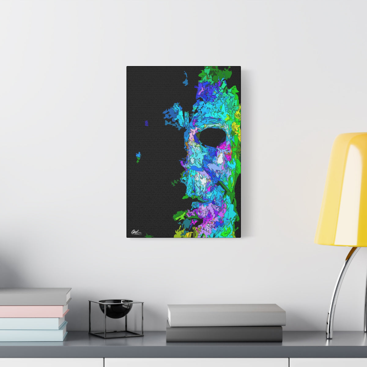 Stalk at Night, Prism Edition canvas beside a yellow desk lamp, pale mask built from neon blue, violet and green shards