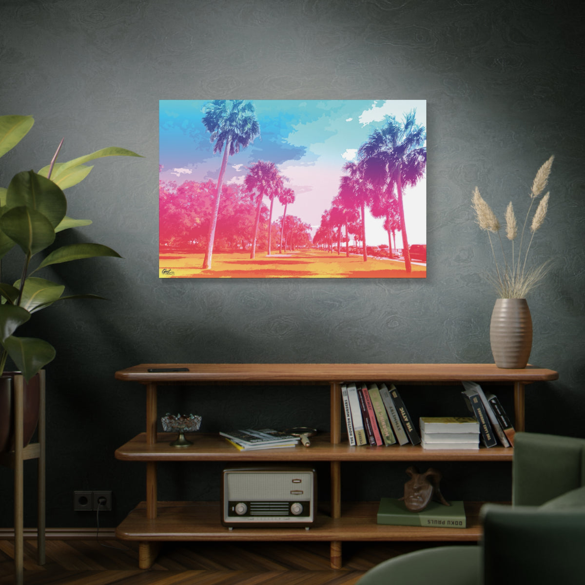 The Battery Tropical Edition large canvas on a green-gray wall over bookshelves, palms in a pink and turquoise sunset