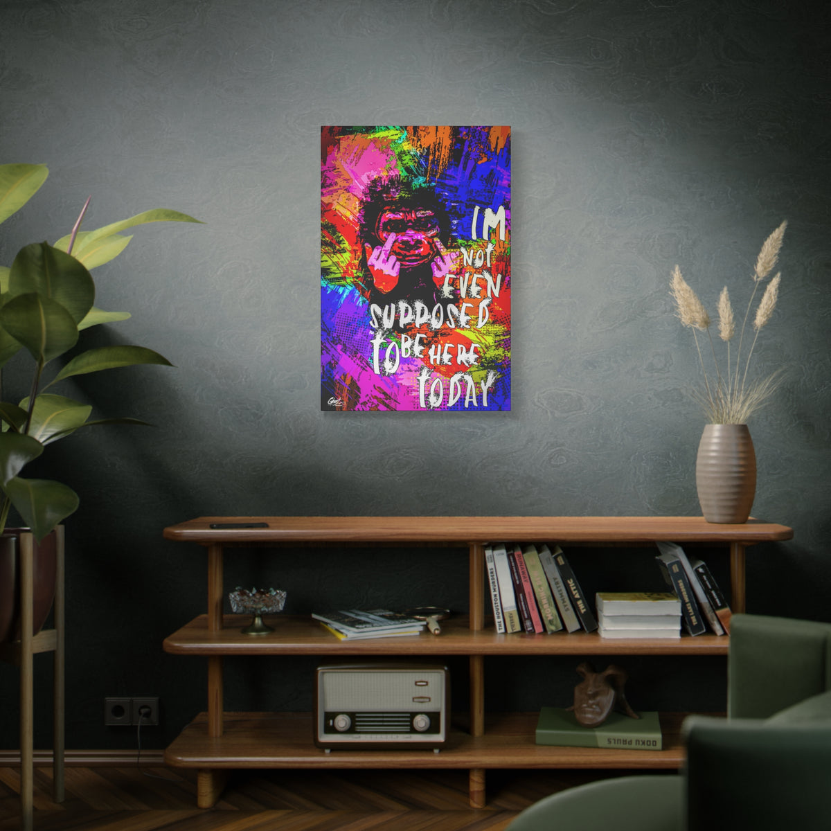 Not Even Supposed to Be Here canvas on a green-gray wall over bookshelves, grinning ape in hot pink and neon brushstrokes