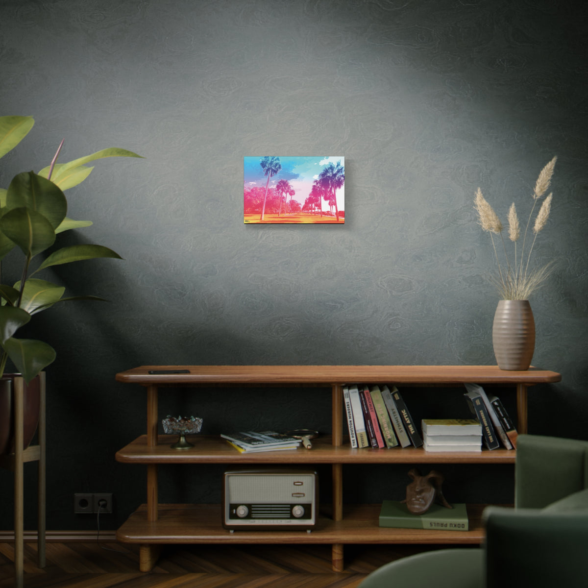 The Battery Tropical Edition small canvas on a green-gray wall over bookshelves, palms in a pink and turquoise sunset
