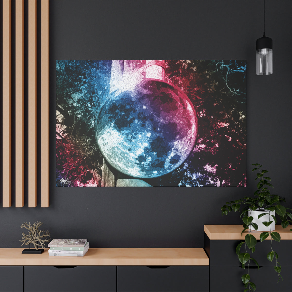 Universe in a Mirror canvas on a charcoal wall by wood slats, moon-like orb in blue and pink film tones in a surreal sky