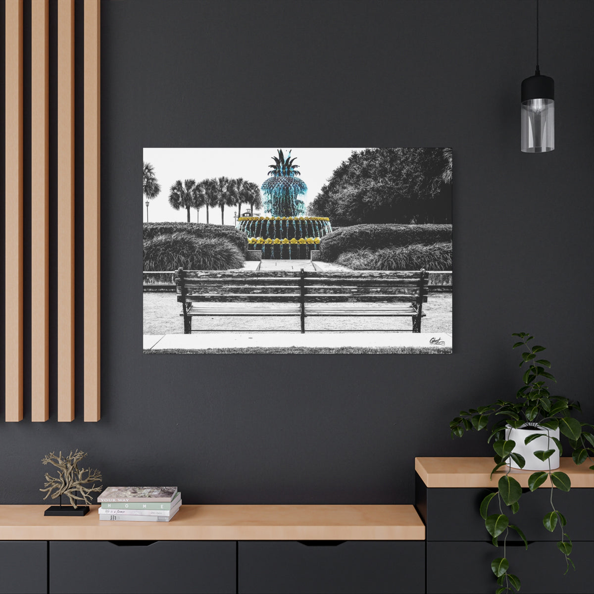 The Pineapple of Peace large canvas on a charcoal wall over an oak shelf, pineapple fountain behind a park bench