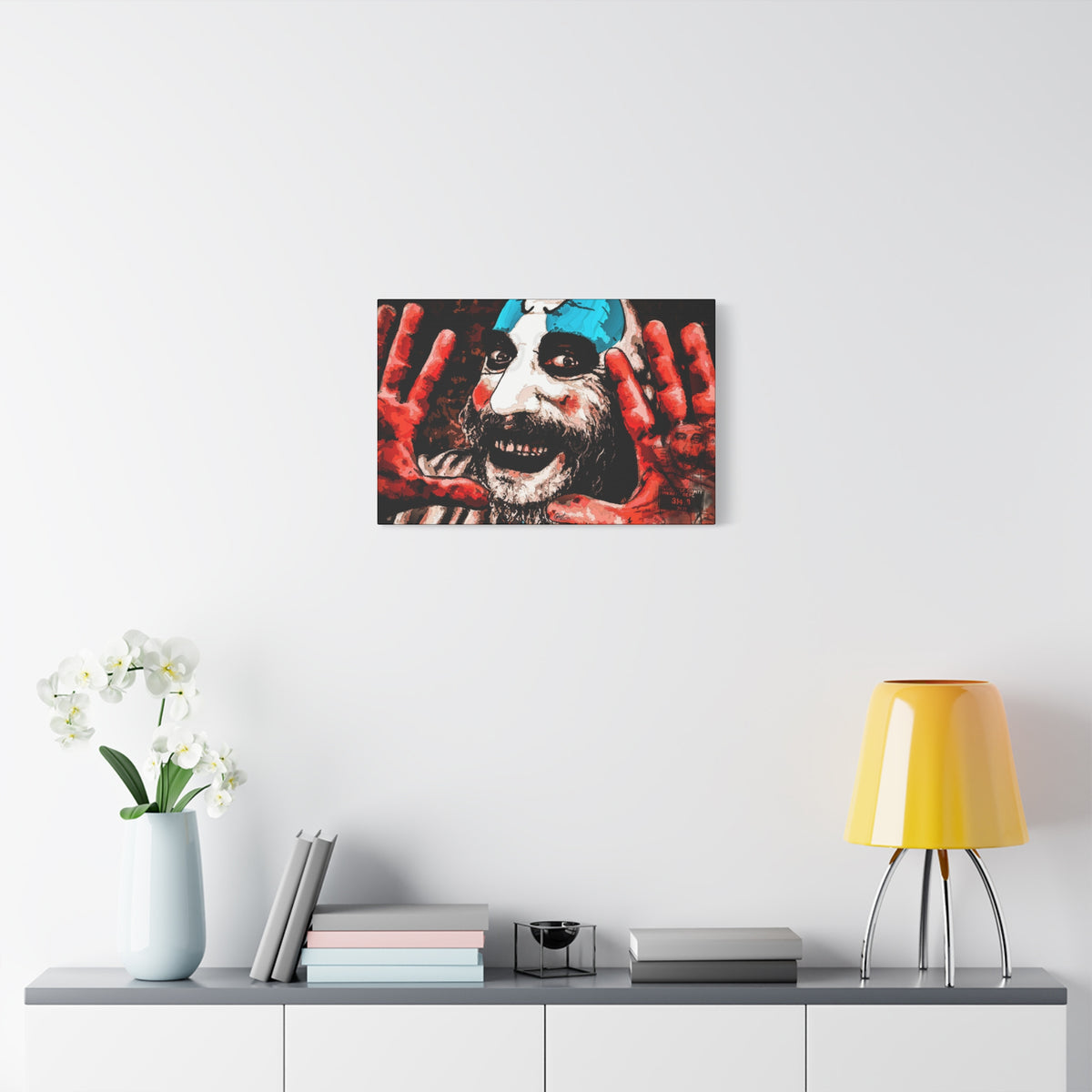 Don't Turn Your Back canvas over a console with white flowers, grinning clown with blue-and-white face paint and red hands
