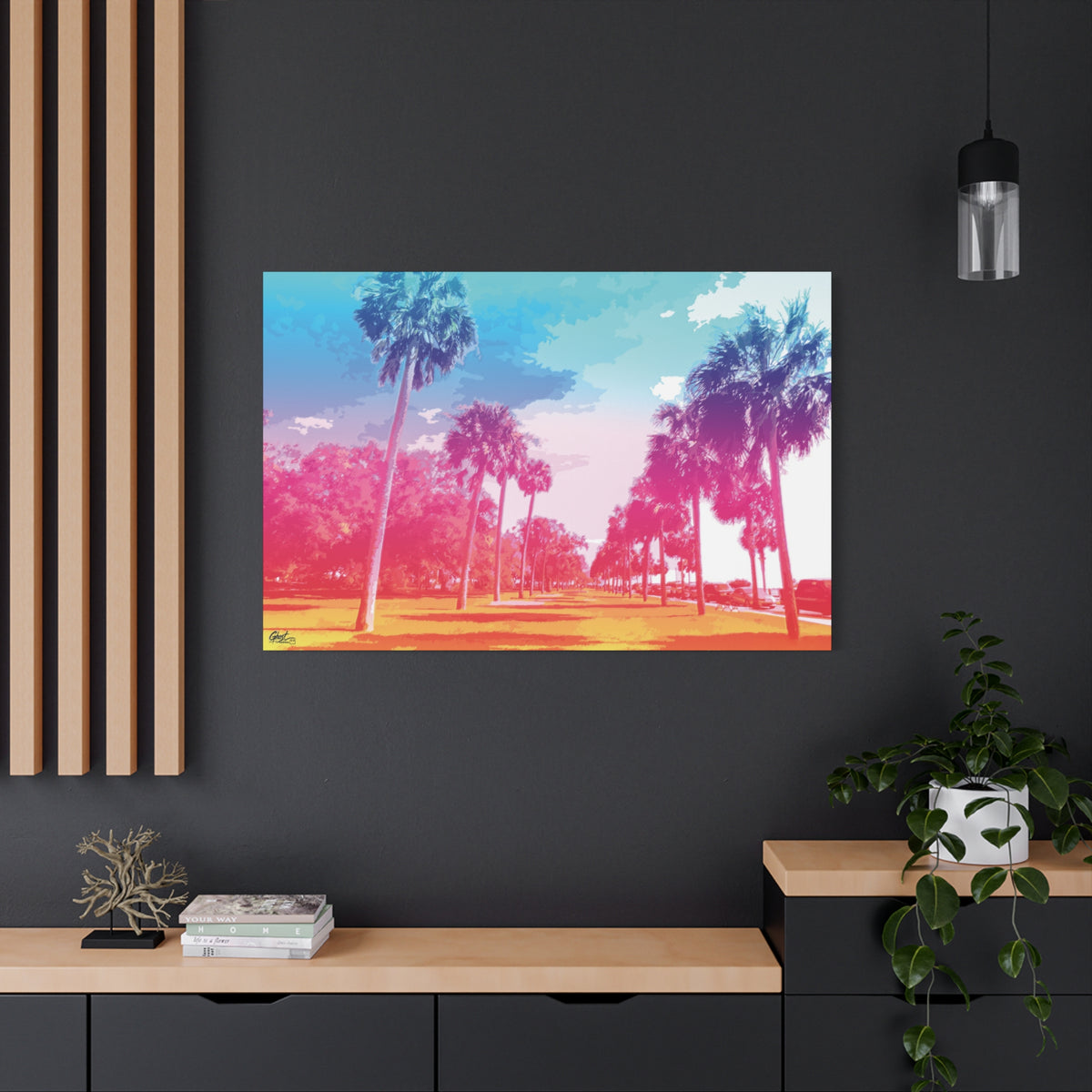 The Battery Tropical Edition large canvas on a charcoal wall over an oak shelf, palms in a pink and turquoise sunset