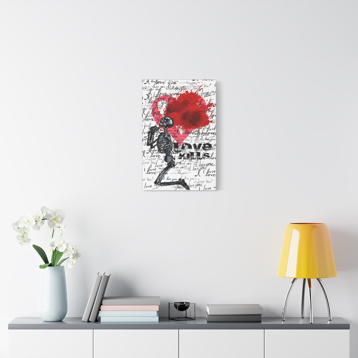 Love Kills small canvas over a console with white flowers, kneeling skeleton before a burst pink and crimson heart