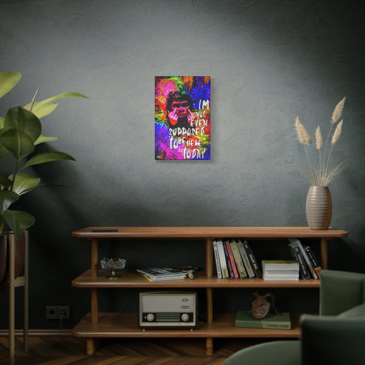 Not Even Supposed to Be Here medium canvas on a green-gray wall over bookshelves, neon pop-art ape over bold halftone color