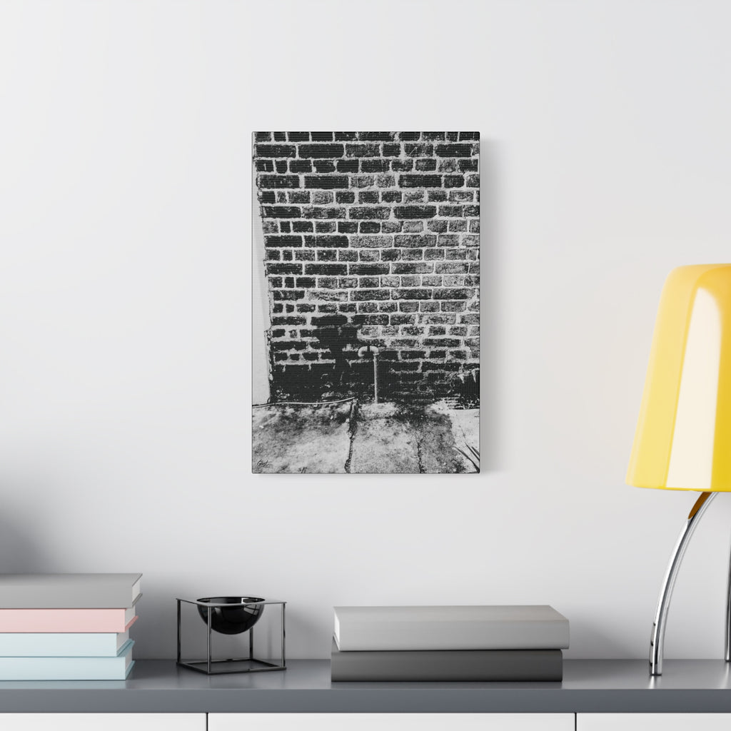 A Little Hiking in Charleston canvas beside a yellow desk lamp, stenciled hiker on a weathered brick wall in black and white