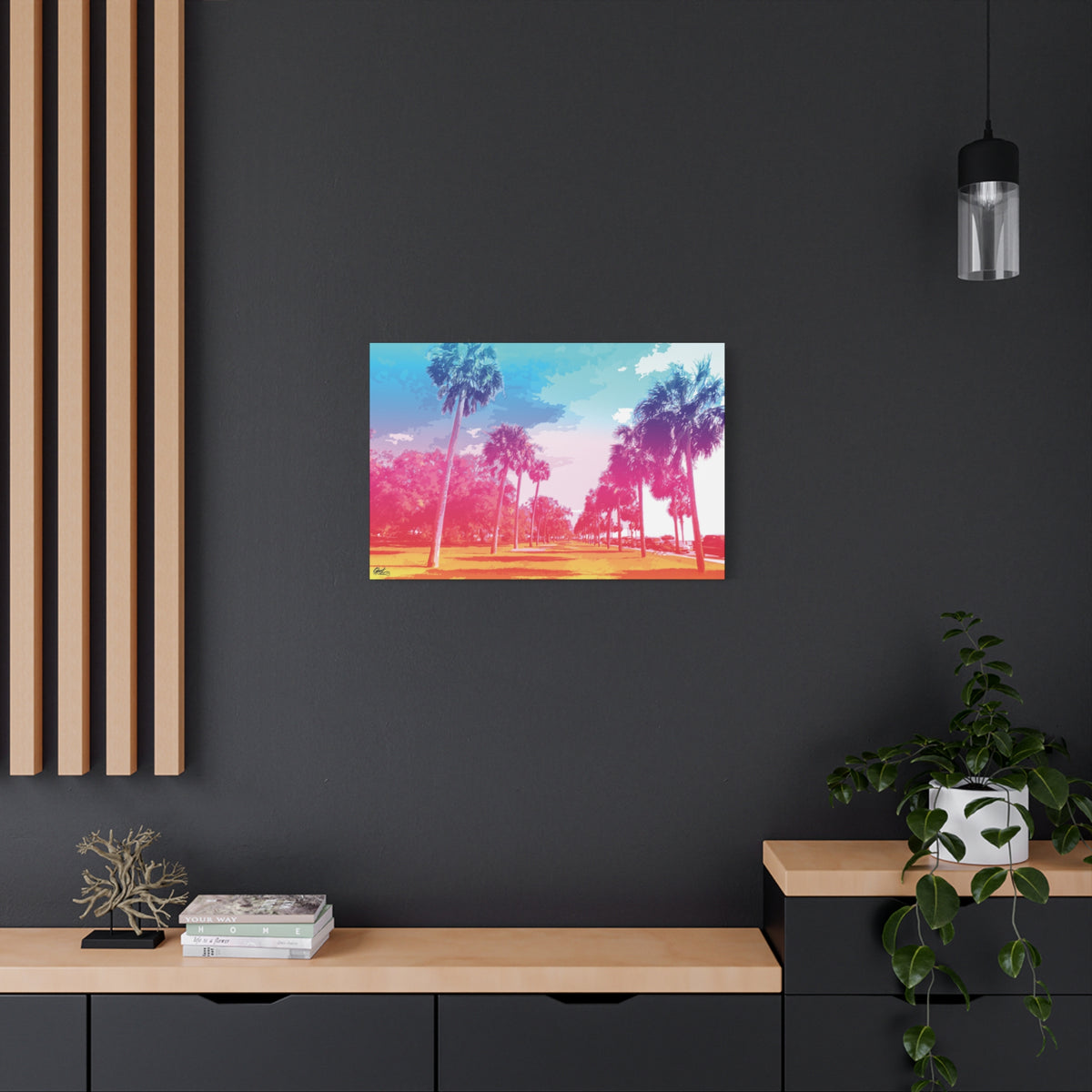 The Battery Tropical Edition medium canvas on a charcoal wall over an oak shelf, palms in a pink and turquoise sunset